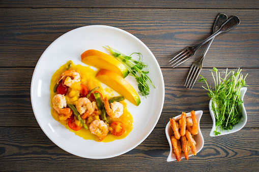 Prawns in mango sauce on wooden table
