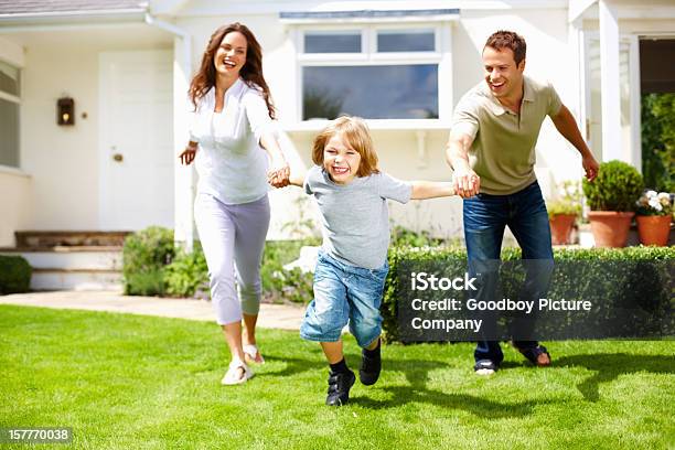 Divertido Niño Pequeño Con Sus Padres Divirtiéndose En Hierba Foto de stock y más banco de imágenes de Familia