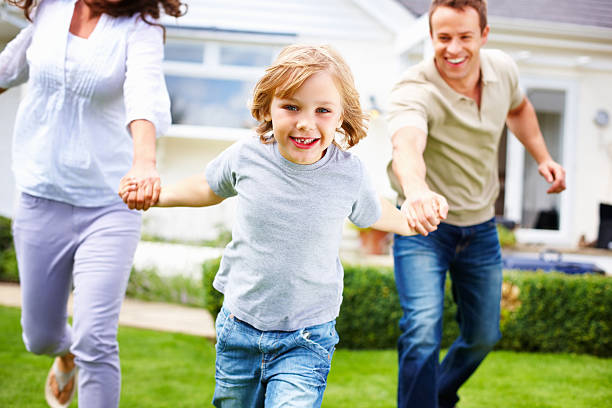 istock boy with his parents having fun in front of house 157770040