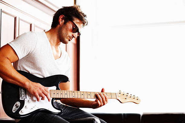 istock Young guy in sunglasses playing guitar 157770092