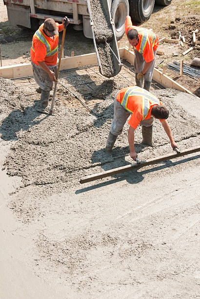 Elevated view of three builders working with concrete stock photo