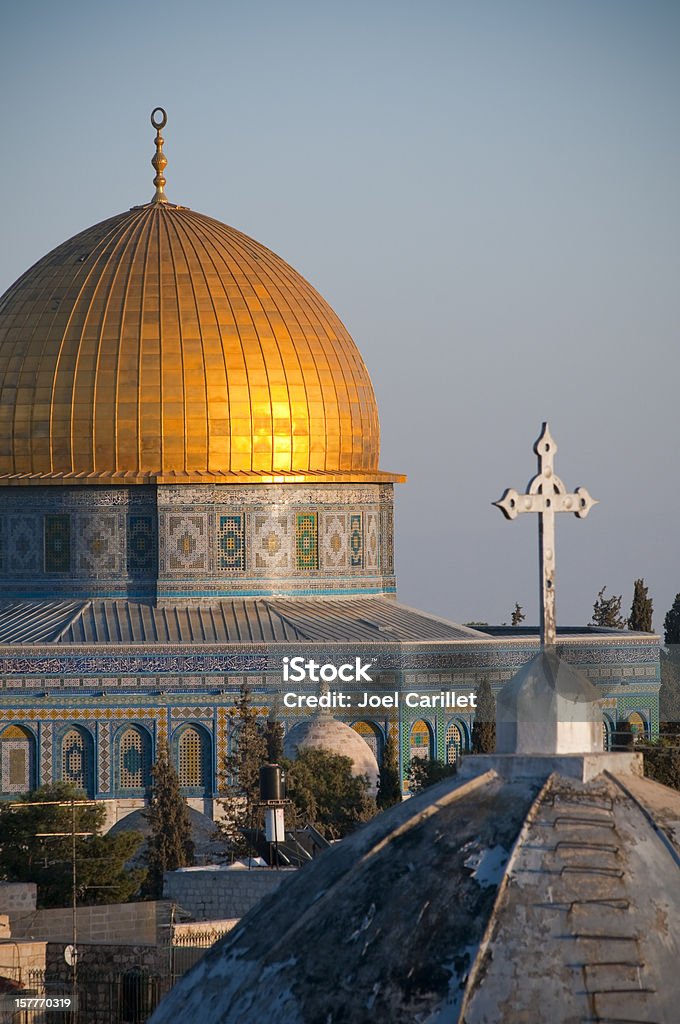 Islam and Christianity Rooftops of two faiths in Jerusalem: A cross on a church and a crescent atop the Dome of the Rock Jerusalem Stock Photo
