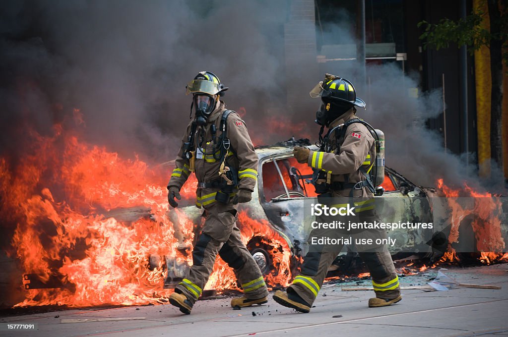 Combatan el frente de un coche de ardor - Foto de stock de Bombero libre de derechos