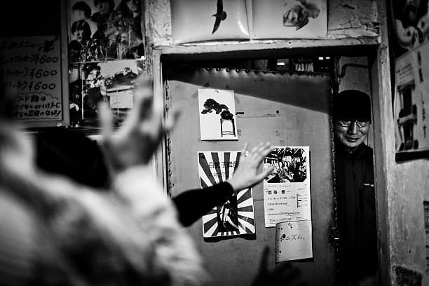 New York City, NY, USA - July 21, 2002: Young Asian couple walks down the stairs of Search & Destroy. A punk rock clothing store. Asian man by the door hangs something. Peddlers and shoppers below. 