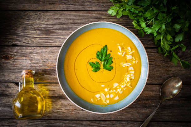 istock Cream carrot soup with almonds on wooden table 1577711637