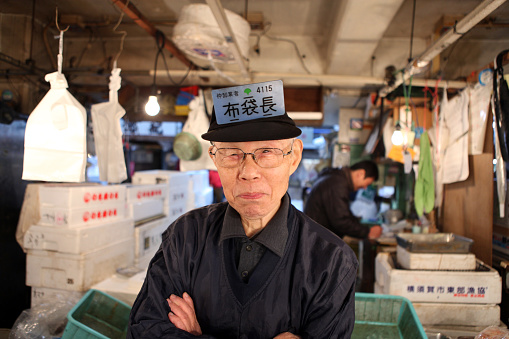Tokyo, Japan - April 12, 2023: fish shop on Tsukiji Fish Market with unidentified people. It is a major tourist attraction. Before 2018, it was the largest wholesale fish market in the world