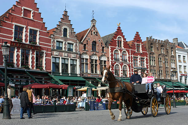 Bruges, Belgium – May 14, 2024: Tourists on the popular market square , grote Markt in Bruges, Belgium
