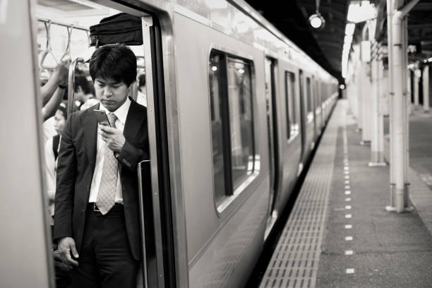 mensagens de texto de homem japonês no comboio - rush hour commuter on the phone tokyo prefecture imagens e fotografias de stock