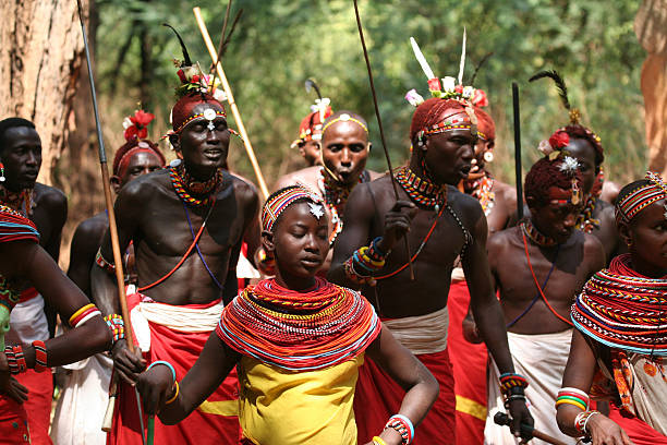 Samburu girls dancing with a group of morani (warriors) Kenya Samburuland, Isiolo district, Kenya - 24th July 2006: 
Samburu tribal morani (warriors, young men) often come down to the safari lodges to earn some money by explaining their tribal traditions and performing traditional dances to tourists. In this photo, they are wearing traditional clothes and beadwork and some of the morani are decorated with ochre clay. kenyan man stock pictures, royalty-free photos & images