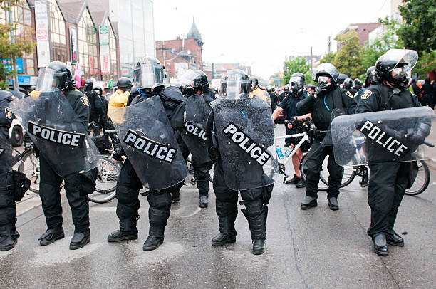reihe von polizisten - bereitschaftspolizist stock-fotos und bilder