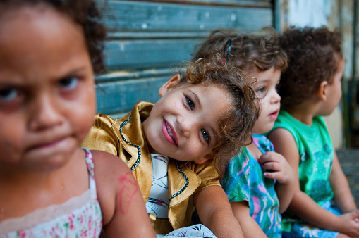 Faces of children, including a beautiful smiling girl, sitting in their neighborhood in the old city of Sidon, Lebanon.