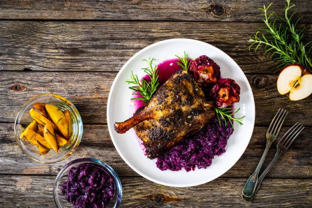 Roast duck thigh and vegetables served on wooden table