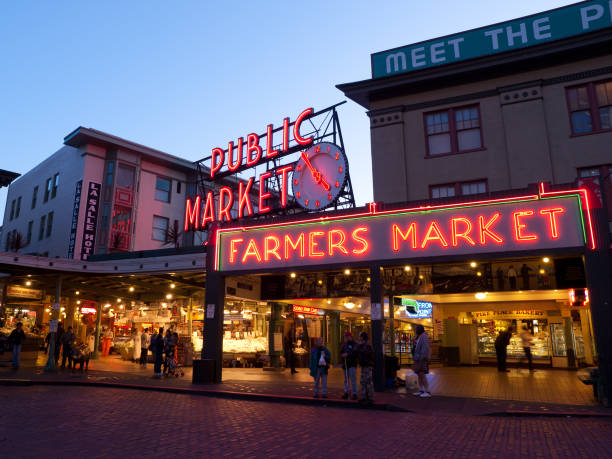 Pike Place Market in Seattle at Dusk Seattle, WA, United States - November 5, 2008: Pike Place Market in Seattle at Dusk - Famous landmark in Seattle overlooking Elliott Bay waterfront in Seattle, Washington, pike place market stock pictures, royalty-free photos & images