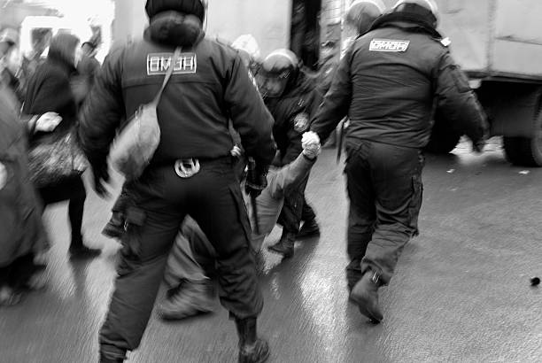 arrestation violente - bereitschaftspolizist stock-fotos und bilder