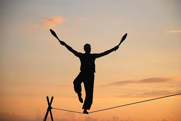 acróbata sobre la cuerda floja al atardecer - tightrope walking circus skill fotografías e imágenes de stock