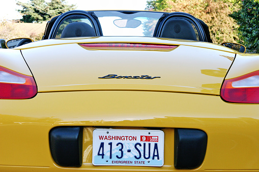 Yellow Porsche 911 parked in front of wealth management office building in Bangkok Ladprao in area of Ratchada 32