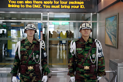 PAJU, DMZ, SOUTH KOREA - NOVEMBER 17, 2006: South Korean Military Police (MP) guards in front of tracks to Pyongyang at the Dorasan Railway Station. Dorasan Station is the northernmost station of the South Korea which is 700m distant from the southern boundary line of  the Demilitarized Zone (DMZ) in between North and South Korea
