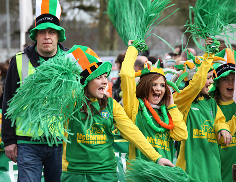 Ratoath, Ireland - March 17, 2010:  Schools girls dressed in Irish colors cheering up at the St Patrick's day parade in an Irish village.