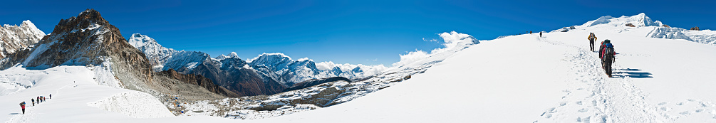 Solukhumbu, Nepal - November 23rd, 2010: Mountaineering teams of climbers, guides, Sherpas and porters making their way up the snowy glacier to Mera Peak (6476m) high camp. Composite panoramic image created from fifteen contemporaneous sequential photographs.