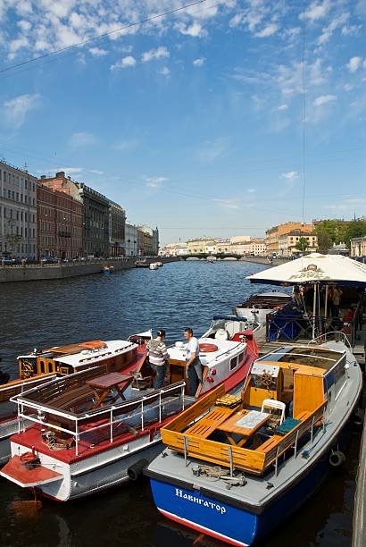 March 11, 2025, Saint Petersburg, Russia. A serene canal in Saint Petersburg lined with colorful historic buildings, showcasing the charm of the city on a sunny day.