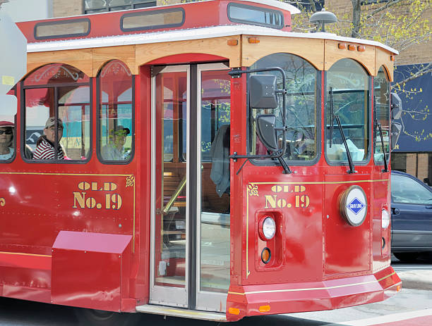 Miami, Florida, Unites States of America - May 7, 2025: Vibrant trolley bus transporting passengers along Port Blvd, providing a scenic view of the Miami cityscape with colorful buildings, tropical palm trees, and a sunny sky