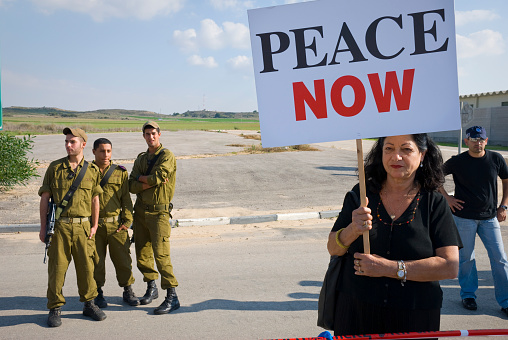 A Peace Now protestor stands with a sign on the Israeli side of the Erez Crossing to the Gaza Strip. (November 18, 2006)