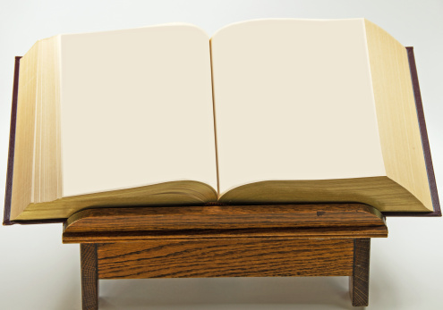 An open book on an oak stand with copy space