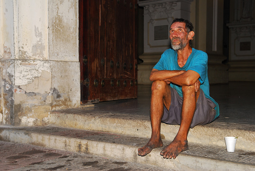 A poor man sits on the steps of the cathedral in Leon, Nicaragua. He was begging for change, and warmly greeted people entering the church.
