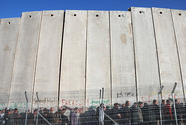 linha de pessoas em pé na parede palestina - muro da cisjordânia fotos - fotografias e filmes do acervo