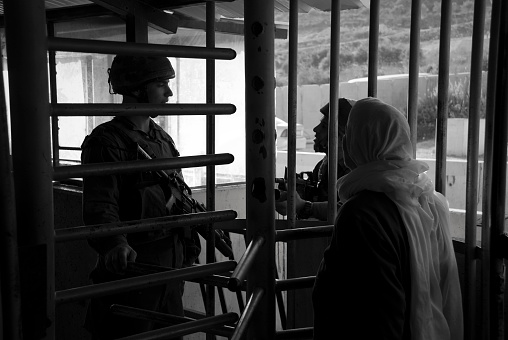 Israeli soldiers and a Palestinian woman at the Huwara checkpoint near the West Bank city of Nablus