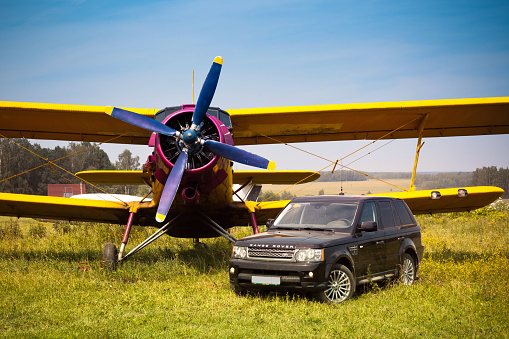 Moscow outskirts, Russia, June 26, 2010 - Old biplane An-2 and Range Rover Sport (Land Rover) at the local airfield