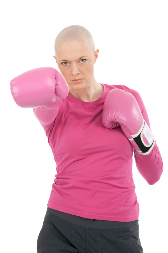 A woman with breast cancer wearing boxing gloves.