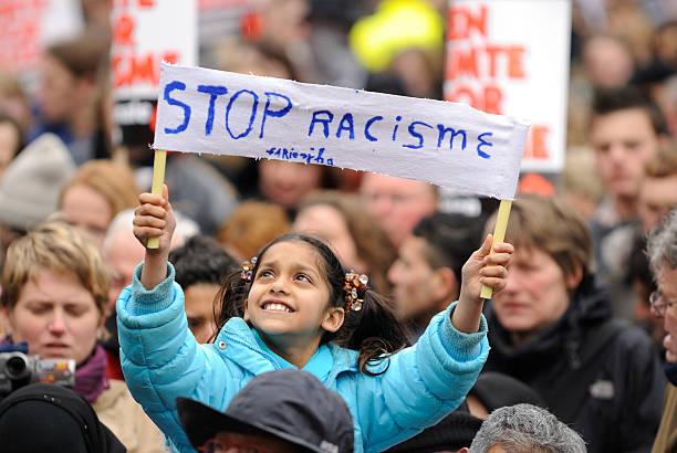 chica sosteniendo un banner en una protesta contra el racismo - editorial outdoors vertical amsterdam fotografías e imágenes de stock