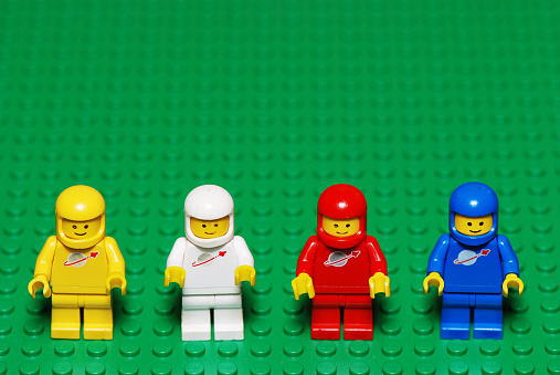 Pila, Italy - April 4, 2011: A group of four astronaut Lego characters from the 80s on a green Lego surface. LEGO are famous construction toys manufactured by the Lego Group, a company based in Billund, Denmark.