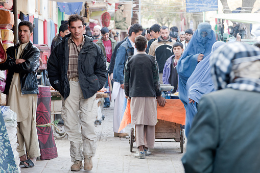Kabul, Afghanistan - November 18, 2008: Man walking amongst a crowd of people in downtown Kabul