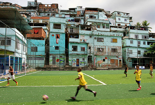 chłopcy gry w piłkę nożną w fawela - playing field kids soccer goalie soccer player zdjęcia i obrazy z banku zdjęć