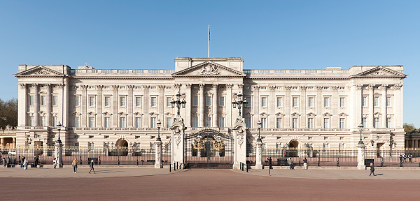 Warm sunlight of daybreak illuminating the iconic facade of Buckingham Palace at the end of The Mall in the heart of London, UK.