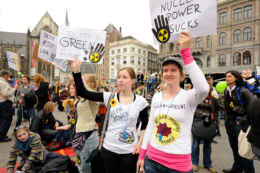 Diverse young people standing up for the earth. Group of multicultural youth activists carrying posters while marching against climate change. Happy young people joining the global climate strike.
