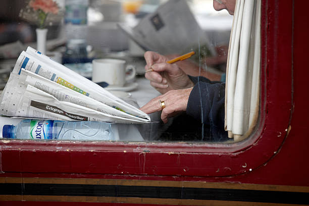 Senior man reading a newspaper in the tran in Slovenia, Europe. Nikon D850.