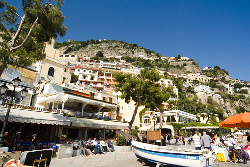 View on Italian coastal town Positano on Amalfi coast from terrace with flowers and trees, Campania, Italy. Popular resort or travel destination