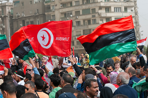 The flags of Libya and Tunisia are carried through Tahrir Square in Cairo, Egypt during the early days of the Arab Spring in Febuary 2011.