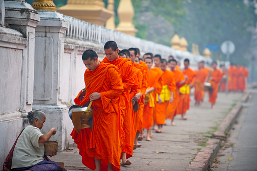 January 22 2023 - Nonthaburi, Thailand : Chinese monks praying in front of the golden statue at Wat Boromracha Kanchanapisek Anusorn (or Wat Leng Noei Yi 2).