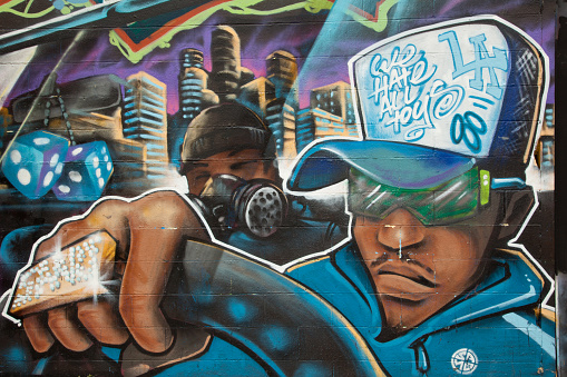 Los Angeles, California, USA - April 21, 2011: A gangster drives under the city lights with his graffiti artist. This graffiti is located adjacent to Paramount Studios on Gower Avenue.