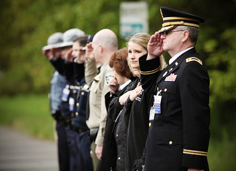 Eugene, Oregon, USA - April 29, 2011: Representatives from multiple police agencies salute a memorial procession honoring a fallen officer.