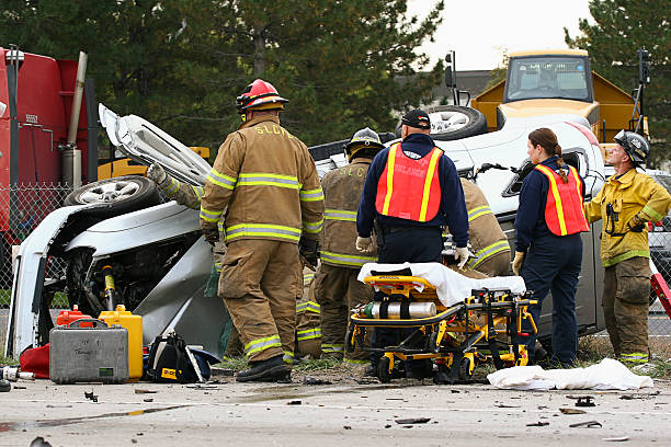 Salt Lake City, Utah, USA - October 14, 2006: Firefighters from the Salt Lake County Unified Fire Authority work to free a trapped passenger from a crashed vehicle. The firefighters are using Hurst Jaws of Life hydraulic tools to cut open the upside down vehicle to gain access.