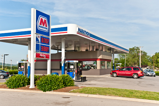 Rental van stopped at a petrol station while on holiday in France. There is a man sitting in the drivers seat.