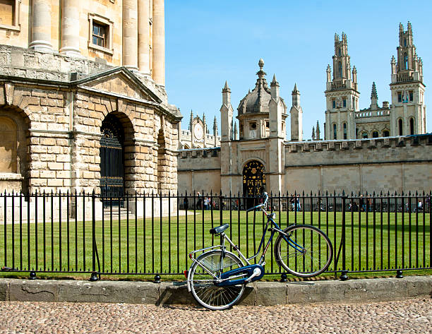 Bicycle tied to railings against bodleian radcliffe library in Oxford Oxford, England - May 1, 2011: Bicycle locked to the Bodleian Radcliffe Library with queens college in the background. Bicycles are the common mode of transport for university students and can be seen all around Oxford city centre. queens college stock pictures, royalty-free photos & images