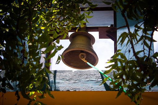 The weathered church bell stands as a symbol of history and tradition, evoking a sense of reverence in its surroundings