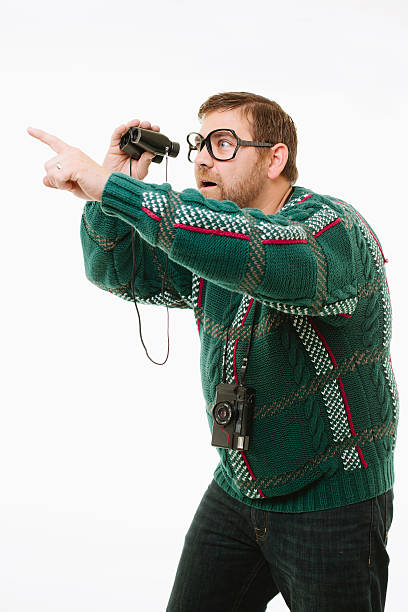 Man points with binoculars stock photo