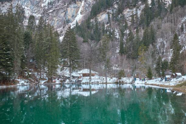 istock a clear lake surrounded by mountains covered with snow and water 1577812037